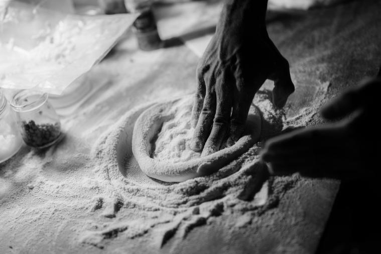 Fresh pizza dough ingredients laid out on a wooden surface