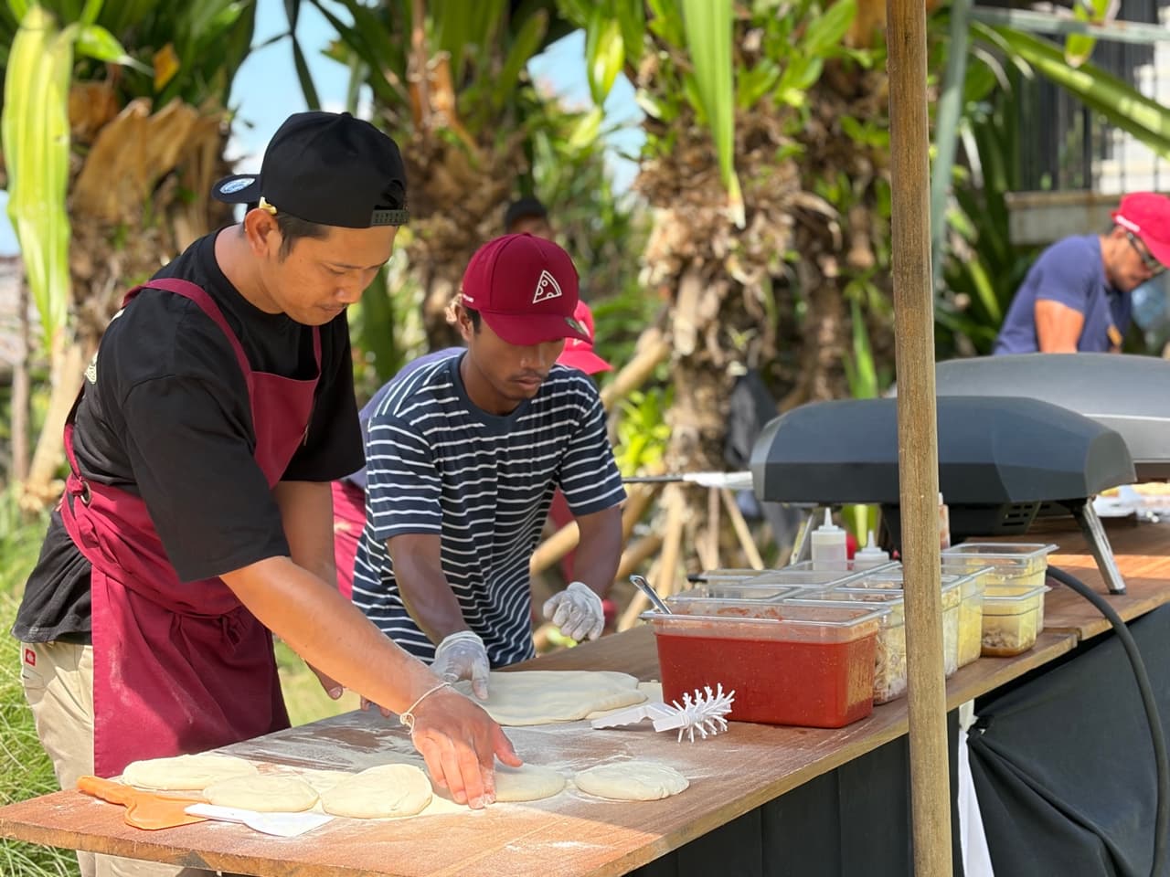Two of our crew stretching dough beside the oven at Arnalaya Beach House, Canggu
