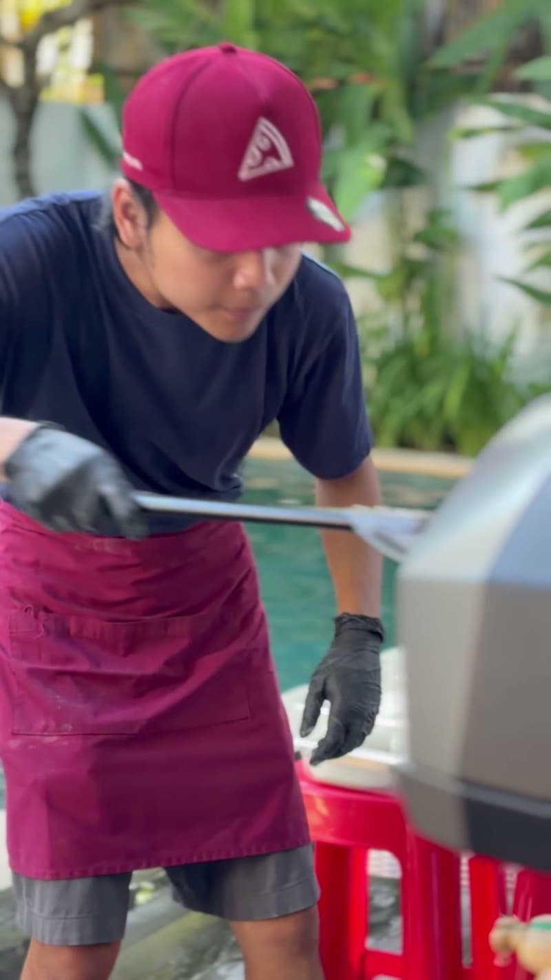 Launching a pizza into the oven by the pool at Villa Karimata, Sanur