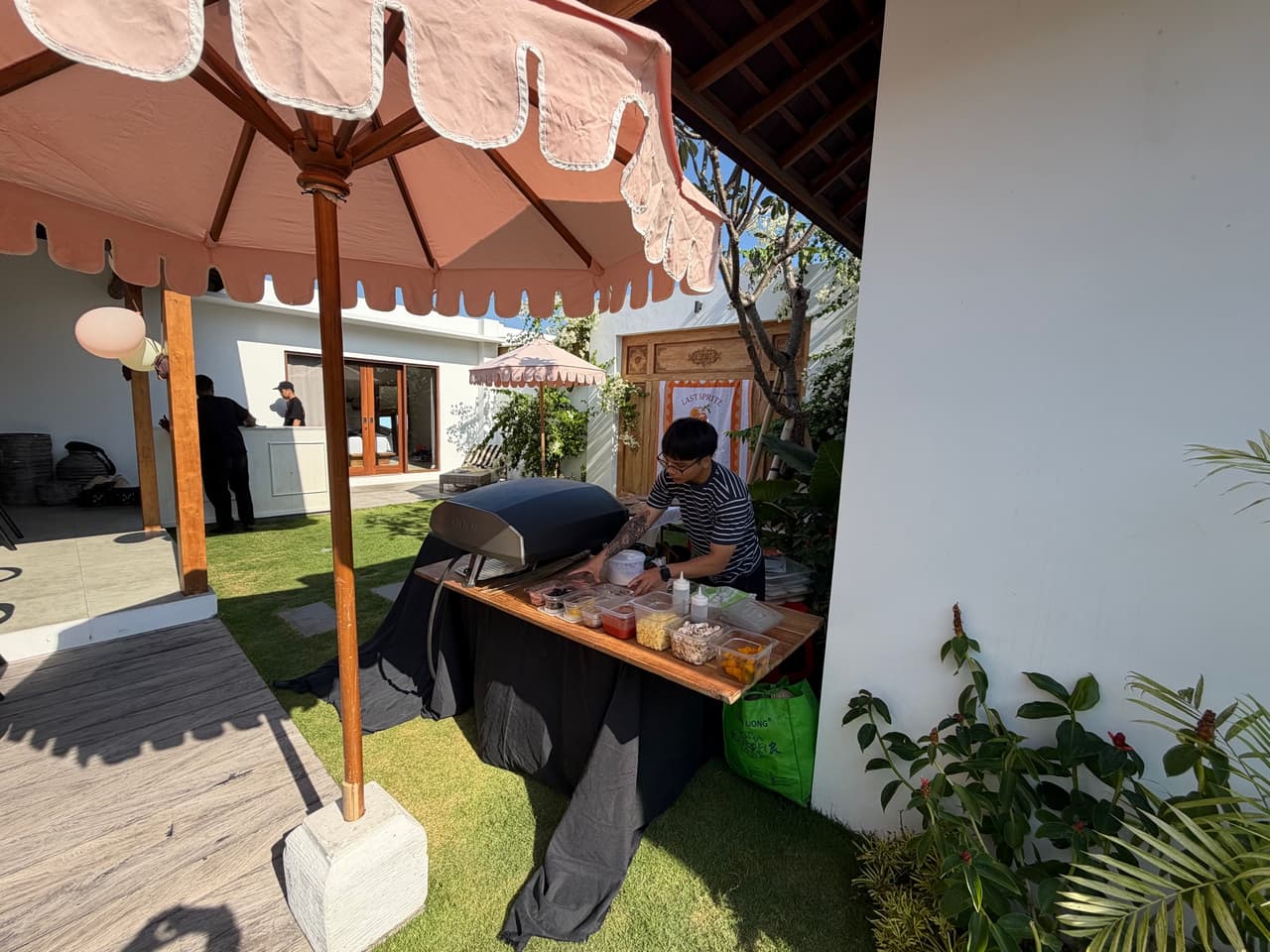 Cooking at the oven under a garden umbrella at Villa Sora, Seminyak