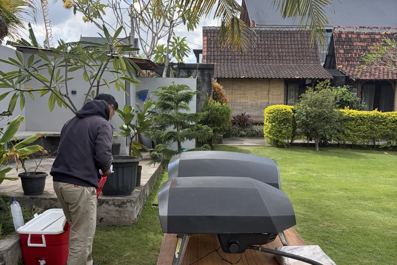 Two pizza ovens on the lawn at Canggu Wooden Green Paradise Villas, tiled roofs and palms behind